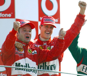 Ferrari driver Rubens Barrichello of Brazil, left, winner of the Grand Prix of Italy, celebrates on the podium with second placed Michael Schumacher of Germany, at the Monza racetrack, Italy, Sunday, Sept.15, 2002. (AP Photo/Luca Bruno)