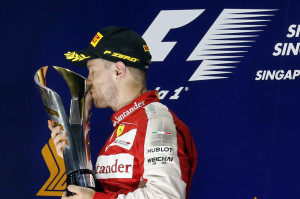 Ferrari driver Sebastian Vettel of Germany kisses the trophy after winning the Singapore Formula One Grand Prix on the Marina Bay City Circuit in Singapore, Sunday, Sept. 20, 2015. (AP Photo/Ng Han Guan)