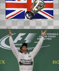 Mercedes driver Lewis Hamilton, of Britain, throws his trophy in the air after winning the world championship win his victory at the Formula One U.S. Grand Prix auto race at the Circuit of the Americas, Sunday, Oct. 25, 2015, in Austin, Texas. (AP Photo/Darron Cummings)
