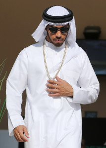 Mercedes driver Lewis Hamilton of Britain walks out of the Mercedes Lounge as he wears the traditional Arab robe and head cover ahead of the Bahrain Formula One Grand Prix at the Formula One Bahrain International Circuit, in Sakhir, Bahrain, Sunday, April 3, 2016. (AP Photo/Kamran Jebreili)