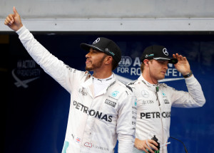 Formula One - F1 - Malaysia Grand Prix - Sepang, Malaysia - 1/10/16 Mercedes' Lewis Hamilton of Britain celebrates pole position as Mercedes' Nico Rosberg of Germany walks by. REUTERS/Edgar Su