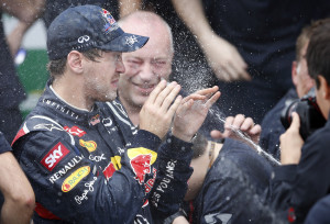 Red Bull driver Sebastian Vettel, of Germany is sprayed with champagne at the end of the Formula One Brazilian Grand Prix at the Interlagos race track in Sao Paulo, Brazil,  Sunday, Nov. 25, 2012. Vettel overcame a first-lap crash to clinch his third straight Formula One championship title on Sunday, finishing sixth in an incident-filled Brazilian Grand Prix won by Jenson Button under pouring rain. (AP Photo/Victor R. Caivano)