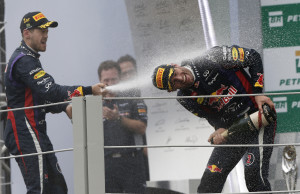 Red Bull driver Sebastian Vettel of Germany. left, pours champagne on teammate Red Bull driver Mark Webber of Australia, during the podium ceremony of the Brazilian Formula One Grand Prix at the Interlagos race track in Sao Paulo, Brazil, Sunday, Nov. 24, 2013. Vettel, who had already wrapped up a fourth straight F1 title, won Formula One's season-ending Brazilian Grand Prix on Sunday. Webber, who had won two of the last four races in Brazil, will be joining Porsche in a sports car series in 2014. The 37-year-old Australian spent 12 seasons in F1, winning nine times and reaching the podium 33 times in 216 races.(AP Photo/Silvia Izquierdo)