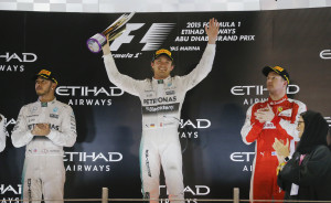 Mercedes driver Nico Rosberg of Germany, center, first place, is flanked by his teammate second place Mercedes driver Lewis Hamilton of Britain and Ferrari driver Kimi Raikkonen of Finland, third place, on the podium after the Emirates Formula One Grand Prix at the Yas Marina racetrack in Abu Dhabi, United Arab Emirates, Sunday, Nov. 29, 2015. (AP Photo/Frank Augstein)