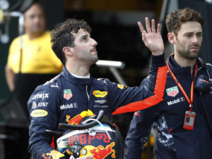Red Bull Racing driver Daniel Ricciardo of Australia, left, waves as he walks down pit lane after crashing out of the qualifying session for the Australian Formula One Grand Prix in Melbourne, Saturday, March 25, 2017. (Brandon Malone/Pool via AP)