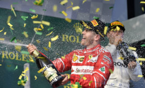 Ferrari driver Sebastian Vettel of Germany sprays champagne as confetti falls around him after winning the Australian Formula One Grand Prix in Melbourne, Australia, Sunday, March 26, 2017. At right is Mercedes driver Valtteri Bottas who finished third. (AP Photo/Andy Brownbill)