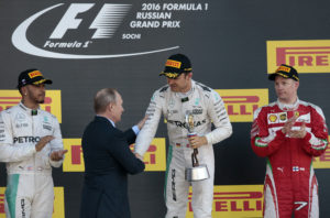 Russia's President Vladimir Putin, second from left, hands over the cup to winning German Mercedes driver Nico Rosberg as British Mercedes driver Lewis Hamilton, left, and Ferrari driver Kimi Raikkonen of Finland look on after the Formula One Russian Grand Prix at the Sochi Autodrom racetrack in Sochi, Russia, Sunday, May 1, 2016.(AP Photo/Ivan Sekretarev)