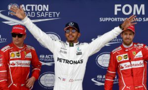 Mercedes' British driver Lewis Hamilton (C) celebrates after winning the pole position next to second placed Ferrari's Finnish driver Kimi Raikkonen (L) and third placed Ferrari's German driver Sebastian Vettel during the qualifying session at the Silverstone motor racing circuit in Silverstone, central England on July 15, 2017 ahead of the British Formula One Grand Prix. / AFP PHOTO / Andrej ISAKOVIC