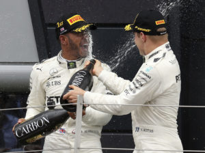 Race winner Mercedes driver Lewis Hamilton of Britain celebrates with teammate and second placed Mercedes driver Valtteri Bottas of Finland, right, on the podium after the British Formula One Grand Prix at the Silverstone racetrack in Silverstone, England, Sunday, July 16, 2017. (AP Photo/Martin Rickett)