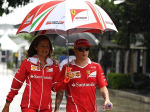Ferrari's Finnish driver Kimi Raikkonen (R) walks under an umbrella in the paddock ahead of the Formula One Malaysia Grand Prix in Sepang on September 28, 2017. / AFP PHOTO / MANAN VATSYAYANA