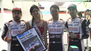 Japanese's driver Kazuki Nakajima (2R) Pole man in 3'15.337 on (Toyota TS050 Hybrid LMP1), poses with his teammates Spain's driver Fernando Alonso (L), Miss 24Hours of Le Mans (2L), and Swiss' driver Sebastien Buemi after the qualifying practice session of the 86th editionof the 24 Hours of Le Mans endurance race, on June 14, 2018, at the Le Mans circuit, northwestern France. / AFP PHOTO / Jean-Francois MONIER