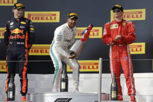 Mercedes driver Lewis Hamilton of Britain celebrates on the podium after winning the French Formula One Grand Prix at the Paul Ricard racetrack, in Le Castellet, southern France, Sunday, June 24, 2018. Second placed Red Bull driver Max Verstappen of the Netherlands, left and third placed Ferrari driver Kimi Raikkonen of Finland, stand on the podium with Hamilton.(AP Photo/Claude Paris)
