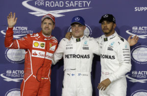 Mercedes driver Valtteri Bottas, center, of Finland, celebrates his pole position with his teammate second placed Lewis Hamilton, right, of Britain, and third placed Ferrari driver Sebastian Vettel, of Germany, during the qualifying session at the Yas Marina racetrack in Abu Dhabi, United Arab Emirates, Saturday, Nov. 25, 2017. The Emirates Formula One Grand Prix will take place on Sunday. (AP Photo/Luca Bruno)