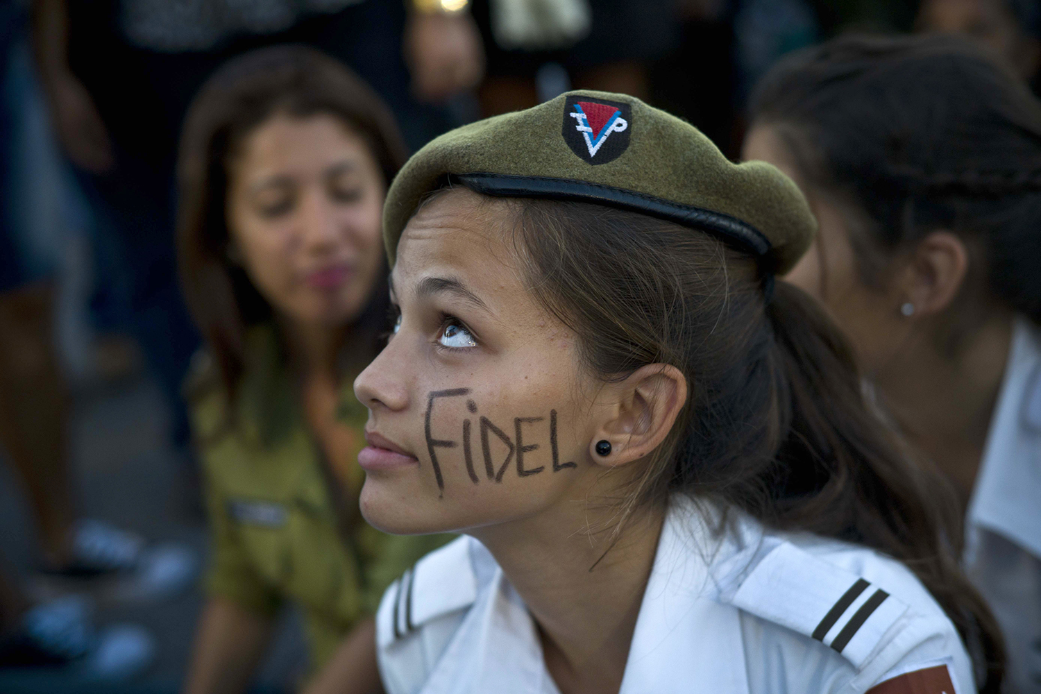 A cadet from the Interior Ministry with the word Fidel painted on her face attends a rally honoring the late Cuban leader at the Revolution Plaza in Havana, Cuba, Tuesday, Nov. 29, 2016. Schools and government offices were closed Tuesday for a second day of homage to Fidel Castro, with the day ending in a rally on the wide plaza where the Cuban leader delivered fiery speeches to mammoth crowds in the years after he seized power.Fidel Castro passed away Friday Nov. 25. He was 90. (AP Photo/Ramon Espinosa)