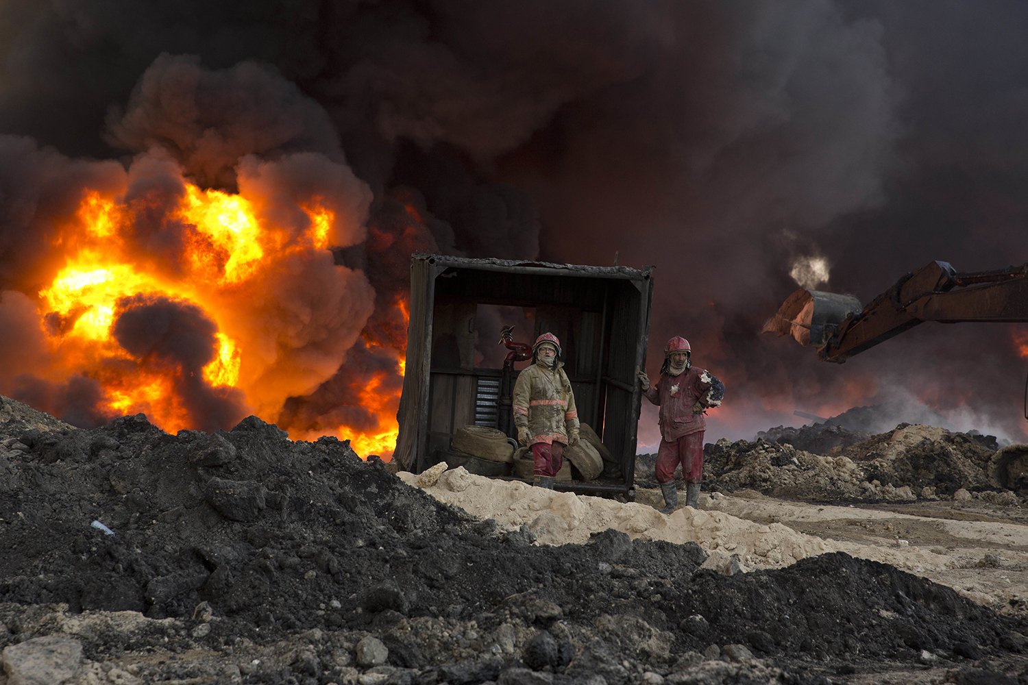 Fire fighters work to well an oil fire set by Islamic State militants in Qayara, south of Mosul, Iraq, Monday, Nov. 28, 2016. (AP Photo/Maya Alleruzzo)
