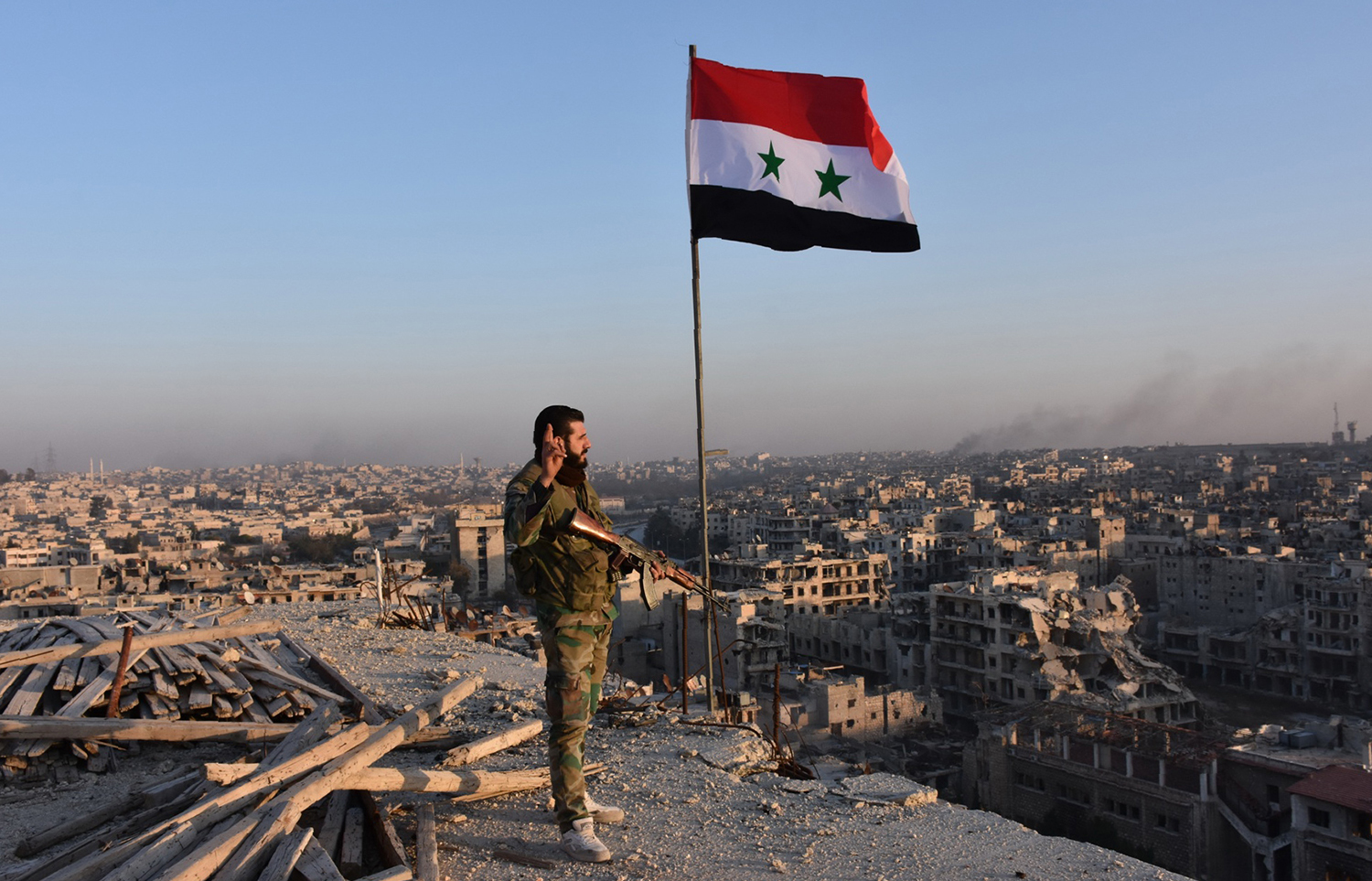 TOPSHOT - Syrian pro-government forces stand on top of a building overlooking Aleppo in the city's Bustan al-Basha neighbourhood on November 28, 2016, during their assault to retake the entire northern city from rebel fighters. In a major breakthrough in the push to retake the whole city, regime forces captured six rebel-held districts of eastern Aleppo over the weekend, including Masaken Hanano, the biggest of those in eastern Aleppo. / AFP PHOTO / GEORGE OURFALIAN / TT / kod 444