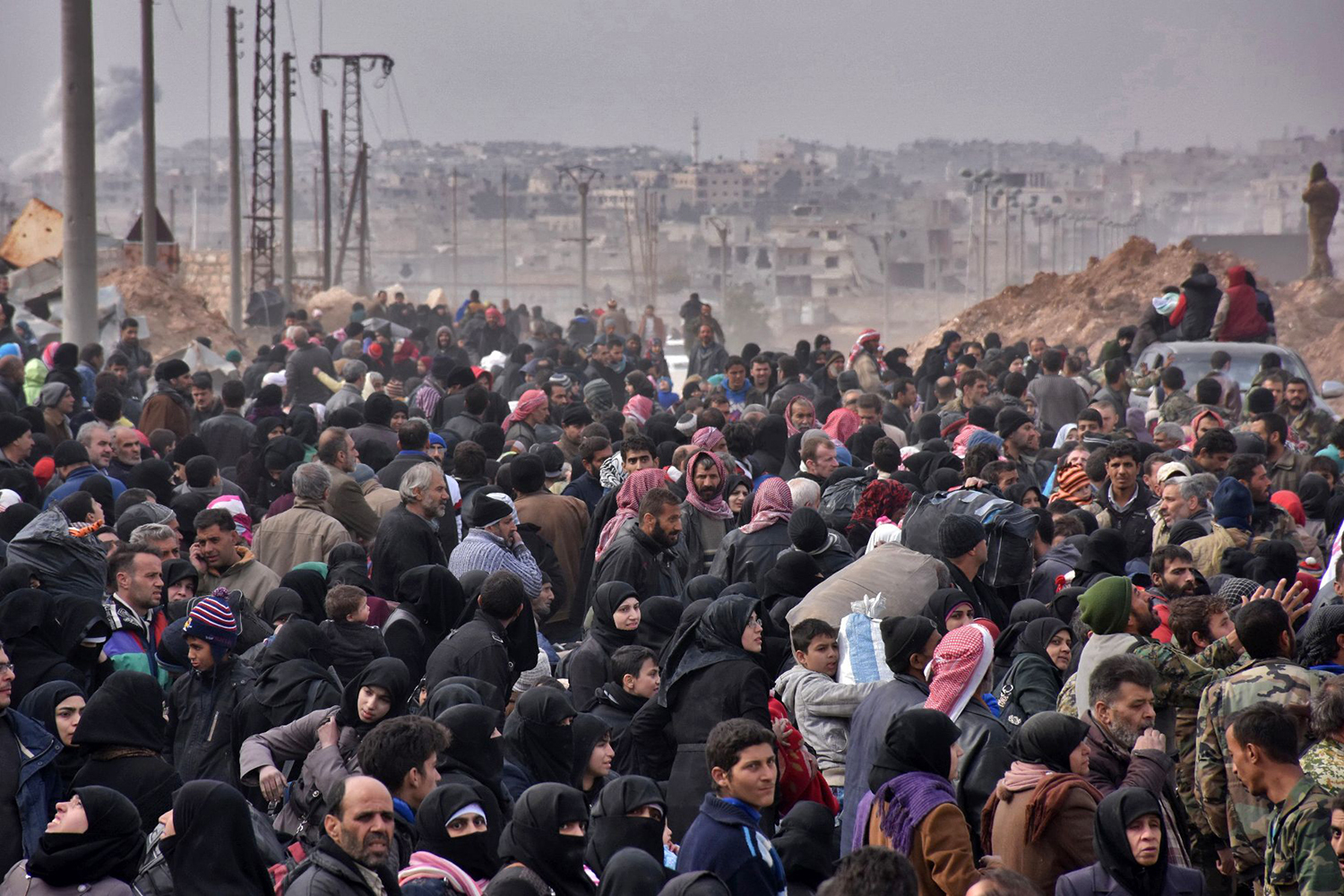 TOPSHOT - Syrian families, fleeing from various eastern districts of Aleppo, queue to get onto governmental buses on November 29, 2016 in the government-held eastern neighbourhood of Jabal Badro, before heading to government-controlled western Aleppo, as the Syrian government offensive to recapture rebel-held Aleppo has prompted an exodus of civilians. The Syrian government offensive to recapture rebel-held Aleppo sparked international alarm, with the UN saying nearly 16,000 people had fled the assault and more could follow. The fighting has prompted an exodus of terrified civilians, many fleeing empty-handed into remaining rebel-held territory, or crossing into government-controlled western Aleppo or Kurdish districts. / AFP PHOTO / George OURFALIAN / TT / kod 444