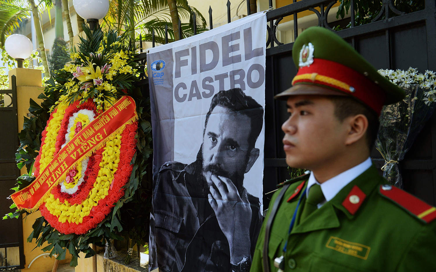 TOPSHOT - The wreath of Vietnam Communist Party Secretary General Nguyen Phu Trong is seen placed next to a large portrait of Fidel Castro posted in front of the Cuban embassy in Hanoi as Trong (not pictured) prepares to pay tribute to the late Cuban leader, on November 28, 2016. Communist heavyweights China and Vietnam were swift to lament the death of Fidel Castro, with Hanoi's state media leading tributes to the loss of a "great friend and comrade". / AFP PHOTO / HOANG DINH NAM / TT / kod 444
