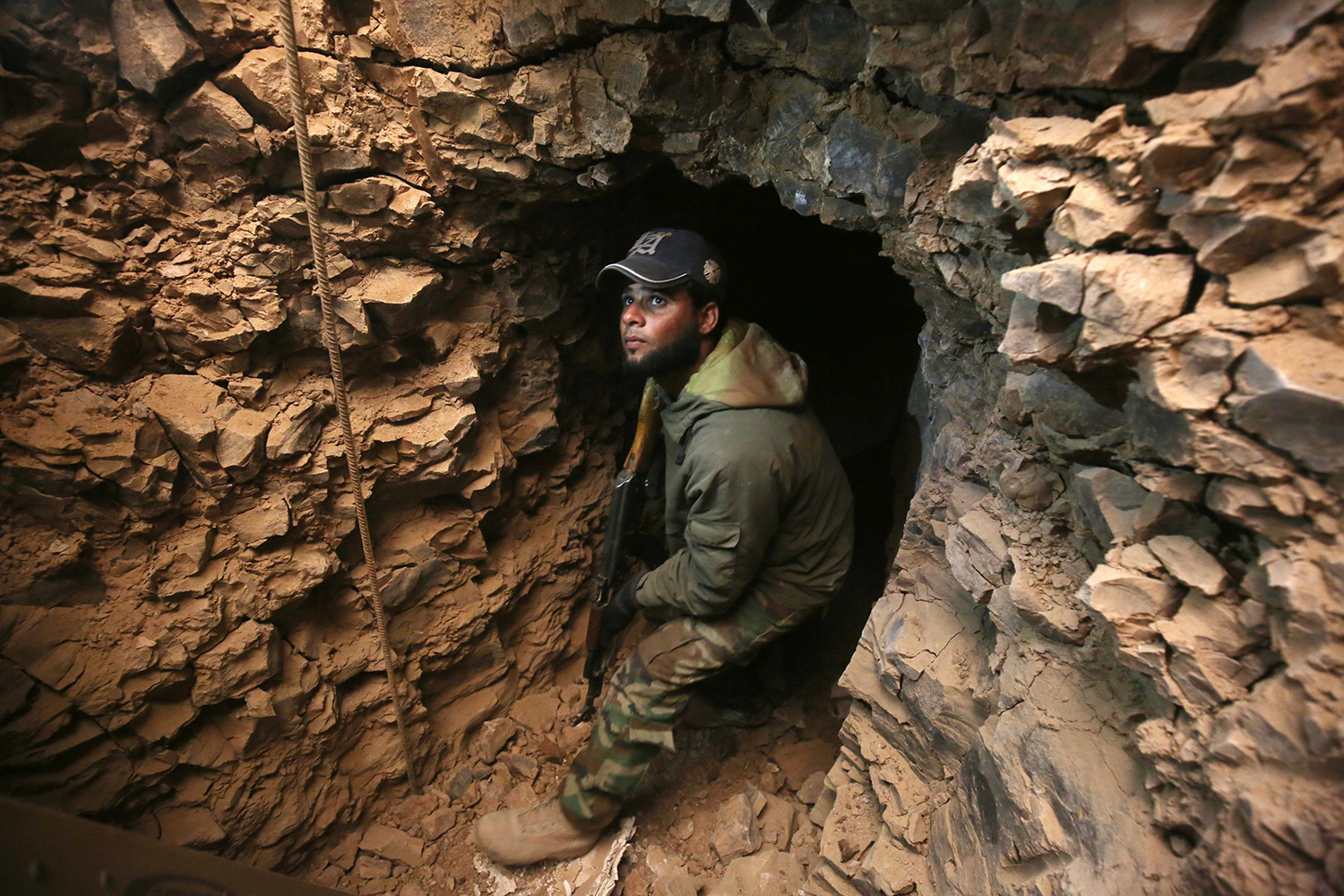 TOPSHOT - An Iraqi Shiite fighter from the Hashed al-Shaabi (Popular Mobilisation) paramilitary forces inspects an underground tunnel in the town of Tal Abtah, south of Tal Afar, on December 10, 2016, after they retook the area during a broad offencive to retake the city of Mosul from Islamic State (IS) jihadists. Hashed al-Shaabi (Popular Mobilisation) paramilitary forces have made progress in recent weeks on a western front targeting Tal Afar town on the road linking Mosul to Syria. On December 8, 2016, the paramilitary forces were clearing Tal Abtah of bombs and booby traps after a fierce, days-long fight to retake it. / AFP PHOTO / AHMAD AL-RUBAYE / TT / kod 444