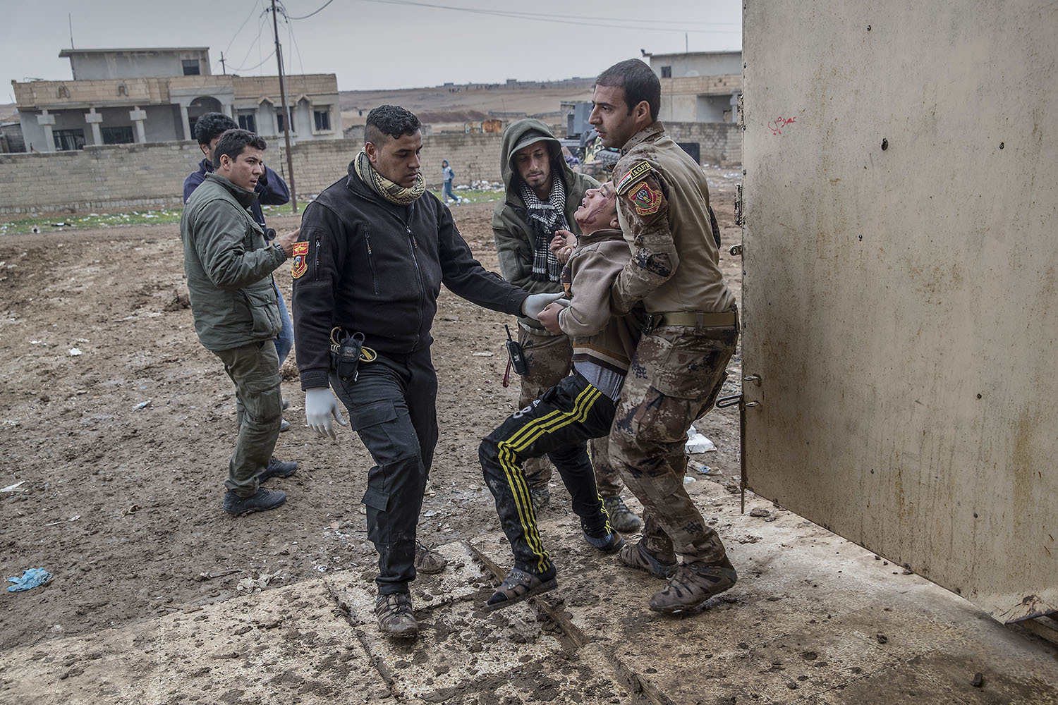 foto : magnus wennman : en man i 40års åldern som blivit skjuten i buken kommer in på kliniken. hans två söner inser snart att han avlidit. fältsjukhuset vid irakiska frontlinjen i mosul. hit kommer skadade och dödade civila och militärer från striderna i mosul. de som inte avlider får akut sjukvård och körs vidare till sjukhuset i erbil.