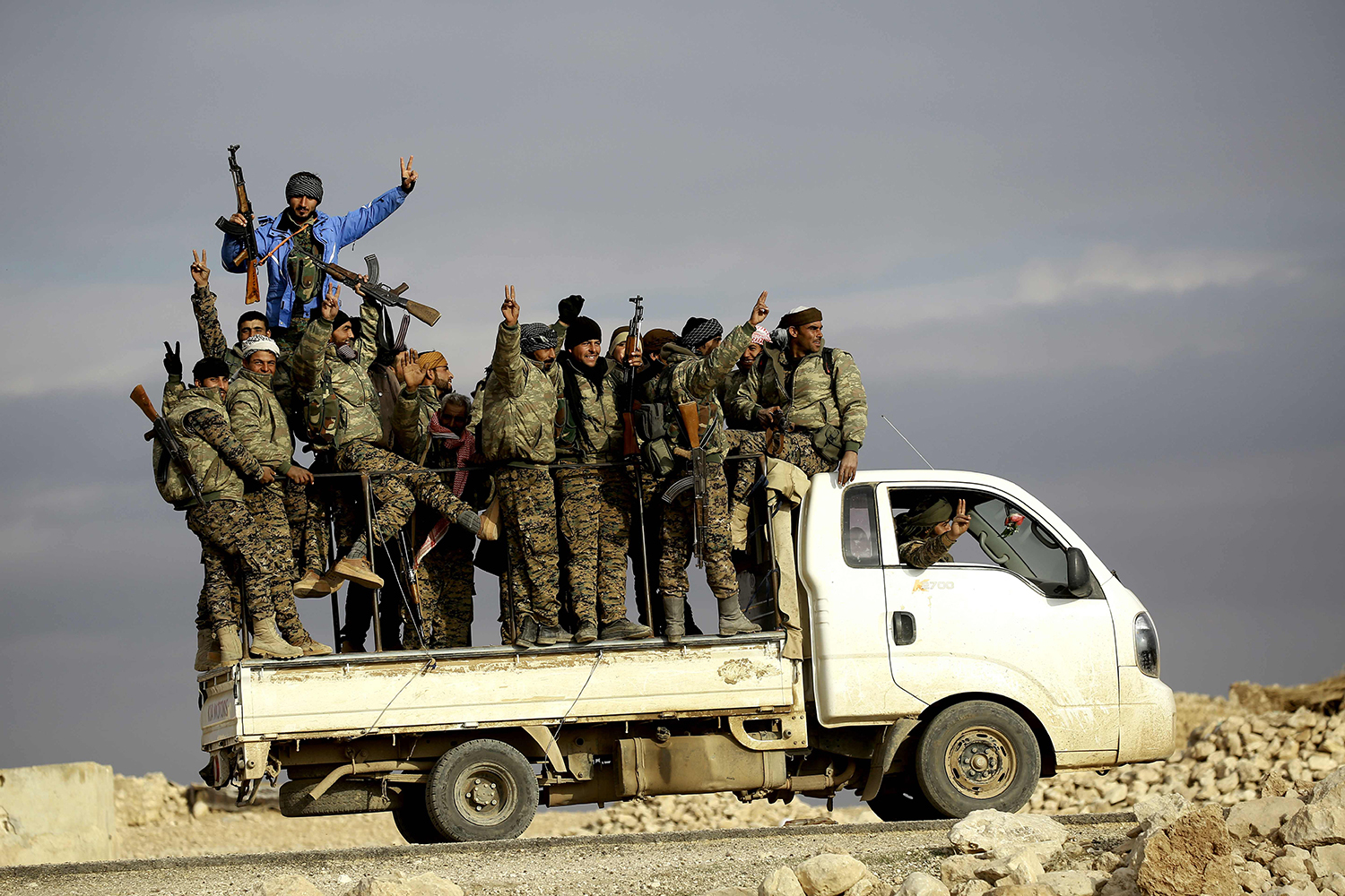TOPSHOT - Fighters from the Kurdish-Arab alliance, known as the Syrian Democratic Forces, wave from a truck driving through the village of Al-Haymar, located on the western outskirts of the Islamic State (IS) bastion of Raqa, on December 11, 2016. The US-backed alliance announced on December 10 it would launch the second phase of its battle for the IS group's de facto Syrian capital of Raqa. / AFP PHOTO / DELIL SOULEIMAN / TT / kod 444