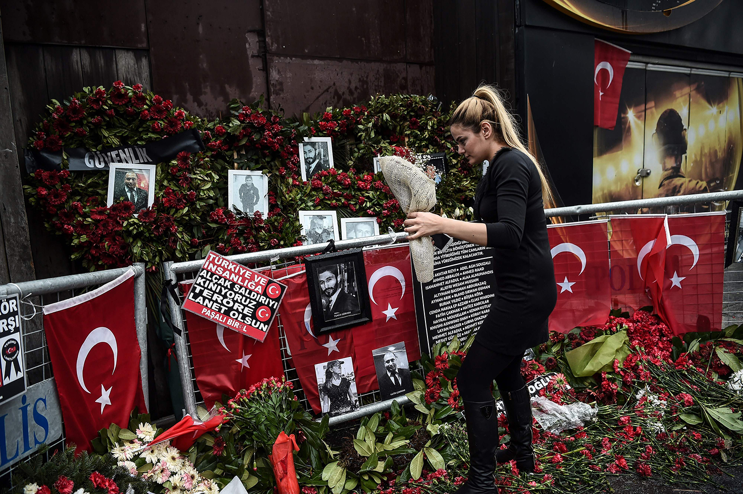 TOPSHOT - A woman lays flowers by a makeshift memorial in front of the Reina nightclub in Istanbul on January 17, 2017, a day after Turkish police arrested the suspected attacker. A 34-year-old Uzbek man suspected of mowing down 39 people at an Istanbul nightclub on New Year's Eve confessed today to the massacre, Turkish authorities said. In a dramatic assault in the early hours of Tuesday morning, Turkish police raided an Istanbul apartment and detained Abdulgadir Masharipov after a massive weeks-long manhunt. / AFP PHOTO / OZAN KOSE / TT / kod 444