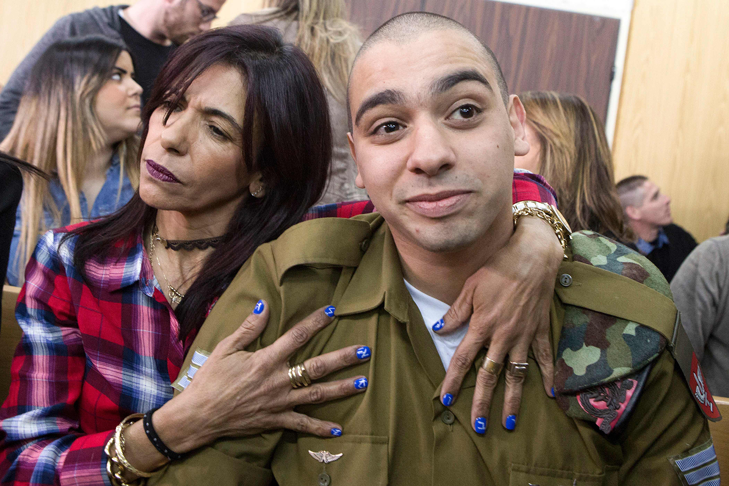 TOPSHOT - Israeli soldier Elor Azaria (R), who shot dead a wounded Palestinian assailant in March 2016, is embraced by his mother Oshra (L) at the start of his sentencing hearing in a military court in Tel Aviv on February 21, 2017. An Israeli military court will sentence a soldier convicted of the manslaughter of a Palestinian attacker in a case which has stoked passions, debate and protest. / AFP PHOTO / POOL / JIM HOLLANDER / TT / kod 444