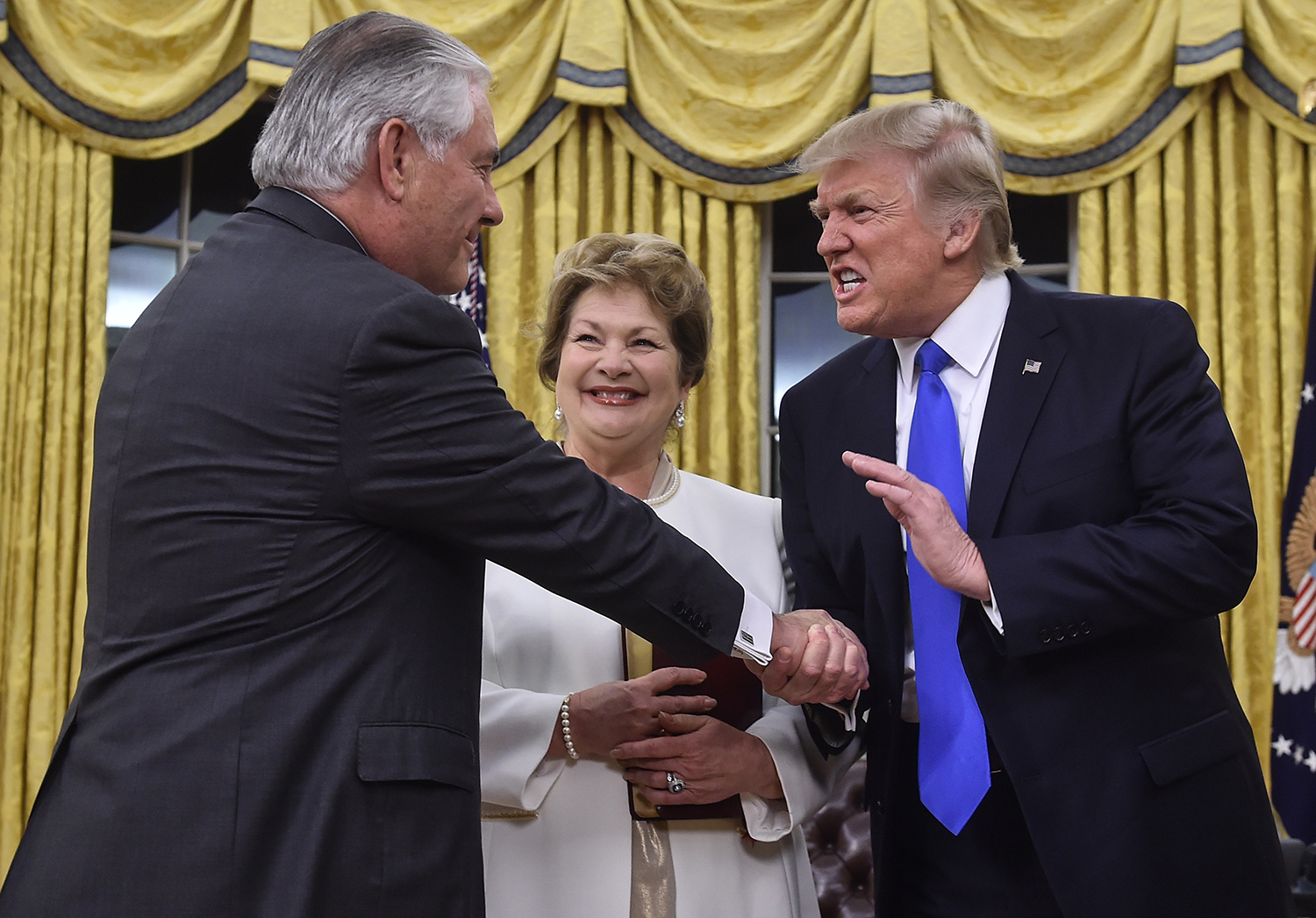 TOPSHOT - US President Donald Trump (R) shakes hands with Rex Tillerson (L) as Tillerson's wife Renda St. Clair look on after Tillerson was sworn in as Secretary of State in the Oval Office at the White House in Washington, DC, on February 1, 2017. President Trump notched a victory with confirmation of Rex Tillerson as his secretary of state, but opposition Democrats girded for battle over several other nominations, including his pick for the US Supreme Court. / AFP PHOTO / NICHOLAS KAMM / TT / kod 444