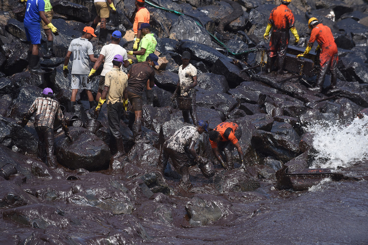 Indian firefighters and volunteers try to clean up oil that has washed ashore in Chennai on February 4, 2017, after an oil tanker and an LPG tanker collided off Kamarajar Port in Ennore, India. Hundreds of students and fishermen were working to clean up an oil spill on India's southern coast that campaigners say threatens the turtles that nest there every year. # Arun Sankar / AFP / Getty