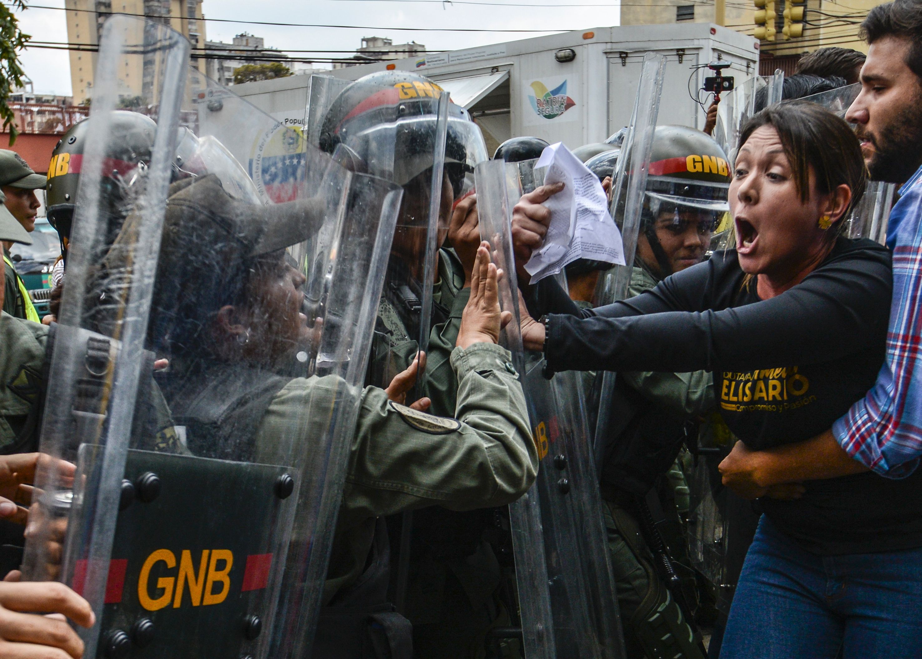TOPSHOT - Venezuelan opposition deputy Amelia Belisario (2nd-R) scuffles with National Guard personnel in riot gear during a protest in front of the Supreme Court in Caracas on March 30, 2017. Venezuela's Supreme Court took over legislative powers Thursday from the opposition-majority National Assembly, whose speaker accused leftist President Nicolas Maduro of staging a "coup." / AFP PHOTO / JUAN BARRETO / TT / kod 444