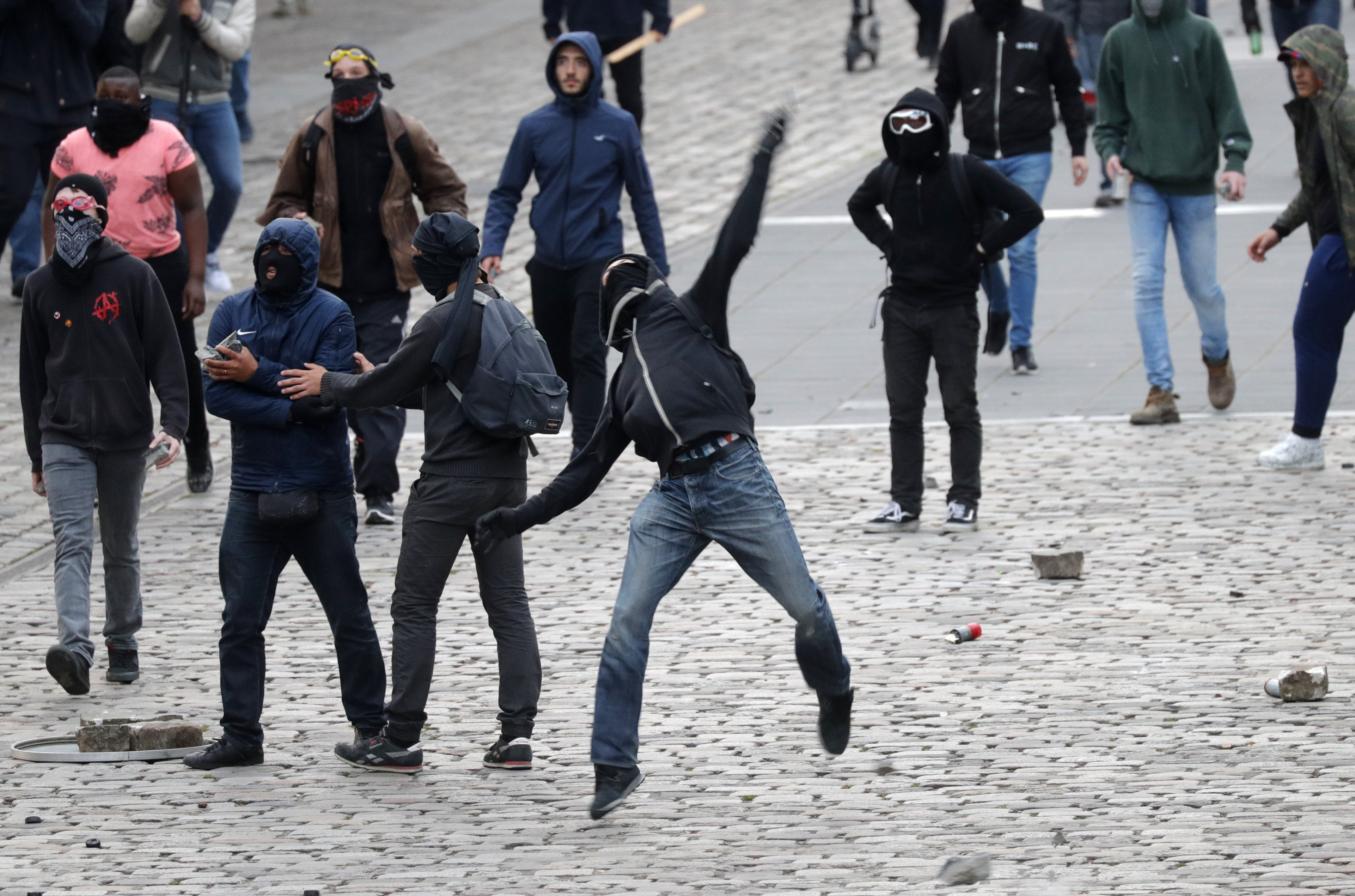 PARIS 2017-04-17 Masked demonstrators throw stones as they protest outside the venue of a campaign rally for Marine Le Pen, French National Front (FN) political party leader and candidate for French 2017 presidential election in Paris, France, April 17, 2017. REUTERS/Philippe Wojazer TPX IMAGES OF THE DAY Photo: / REUTERS / TT / kod 72000