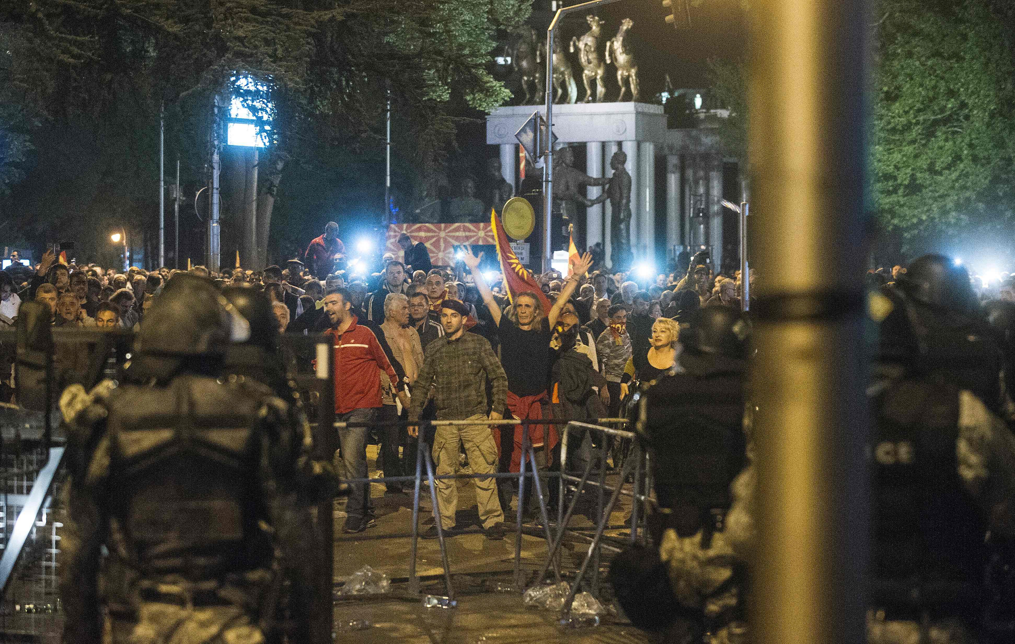 Police face protesters gathered outside Macedonia's parliament after the governing Social Democrats and ethnic Albanian parties voted to elect an Albanian as parliament speaker in Skopje on April 27, 2017. Macedonia's opposition leader was among at least 10 people injured in parliament on April 27 after protesters stormed the building following an allegedly unfair vote for a parliamentary speaker, witnesses and local media reported. The violence erupted after around 100 protesters supporting the rival VMRO-DPMNE party entered parliament waving Macedonian flags and singing the national anthem. / AFP PHOTO / Robert ATANASOVSKI / TT / kod 444