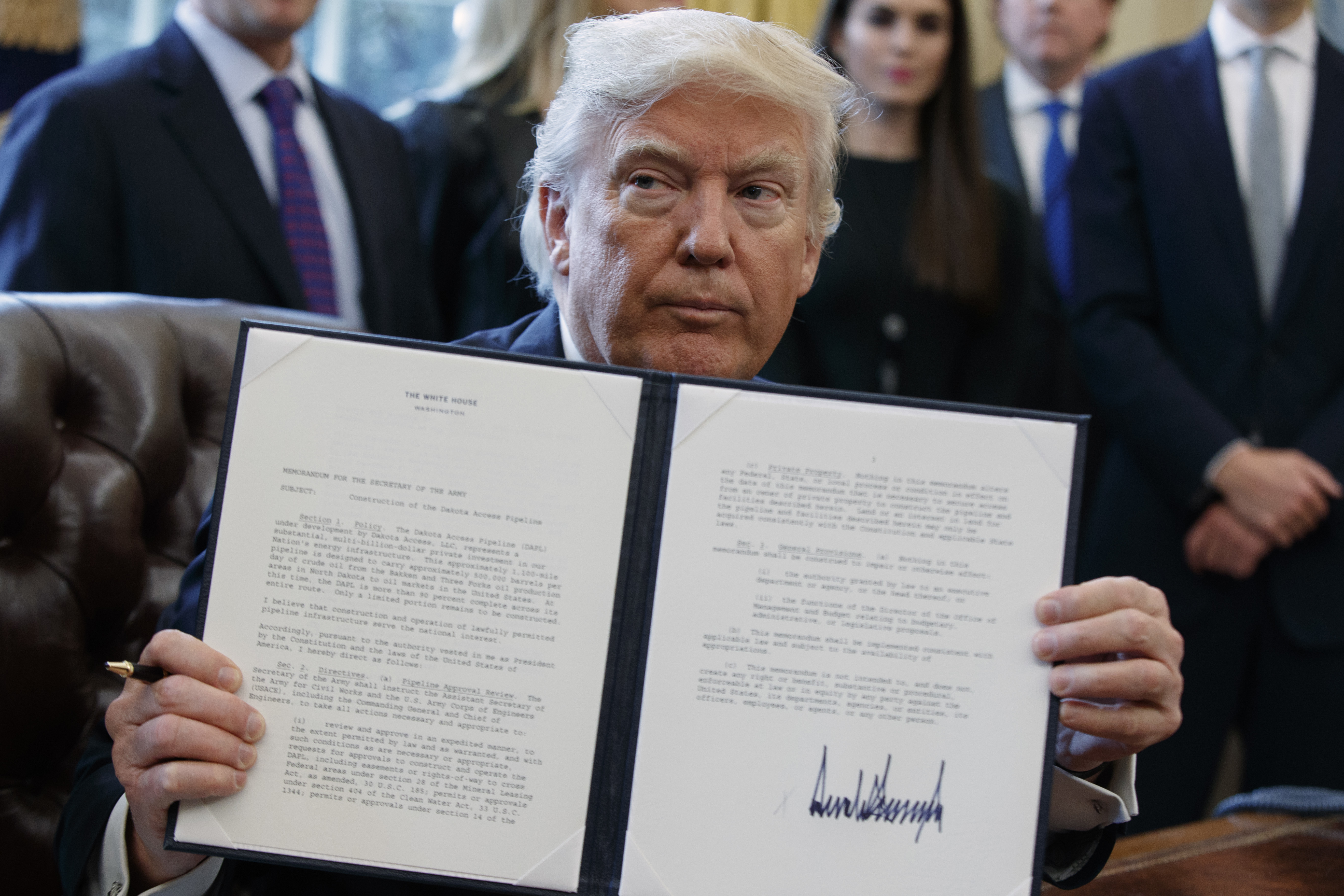 foto : evan vucci : president donald trump shows off his signature on an executive order about the dakota access pipeline, tuesday, jan. 24, 2017, in the oval office of the white house in washington. (ap photo/evan vucci)