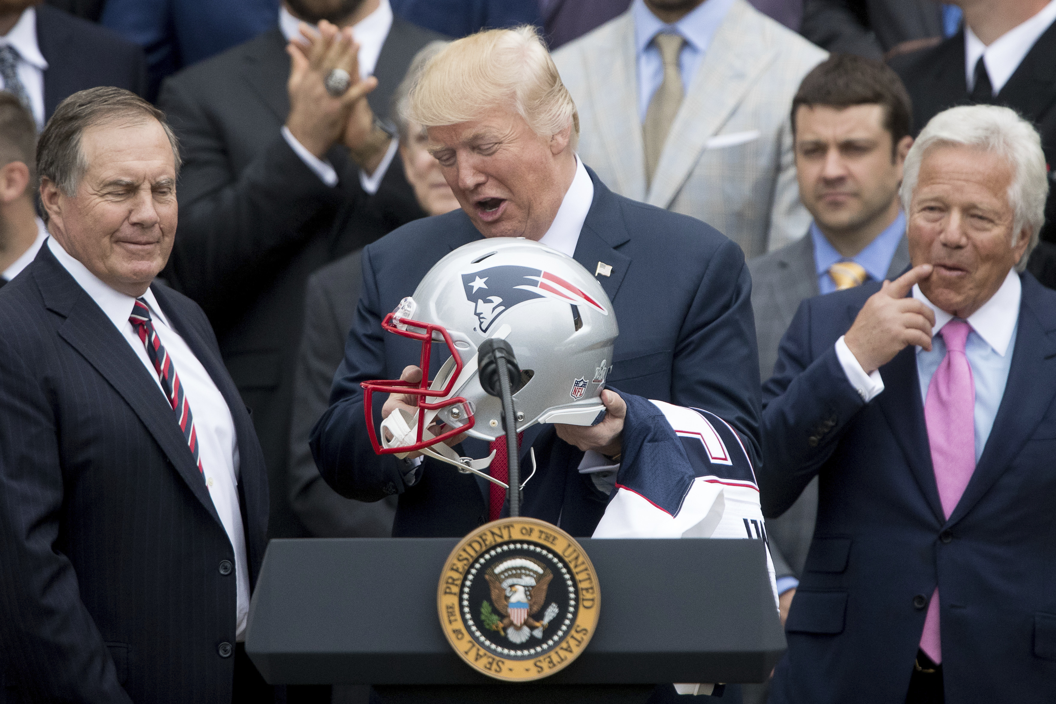 foto : andrew harnik : day 90 - in this april 19, 2017, file photo, president donald trump. flanked by new england patriots head coach bill belichick, left, and owner robert kraft, holds a new england patriots football helmet and jersey during a ceremony on the south lawn of the white house in washington, where he honored the super bowl champion new england patriots for their super bowl li victory. (ap photo/andrew harnik, file)