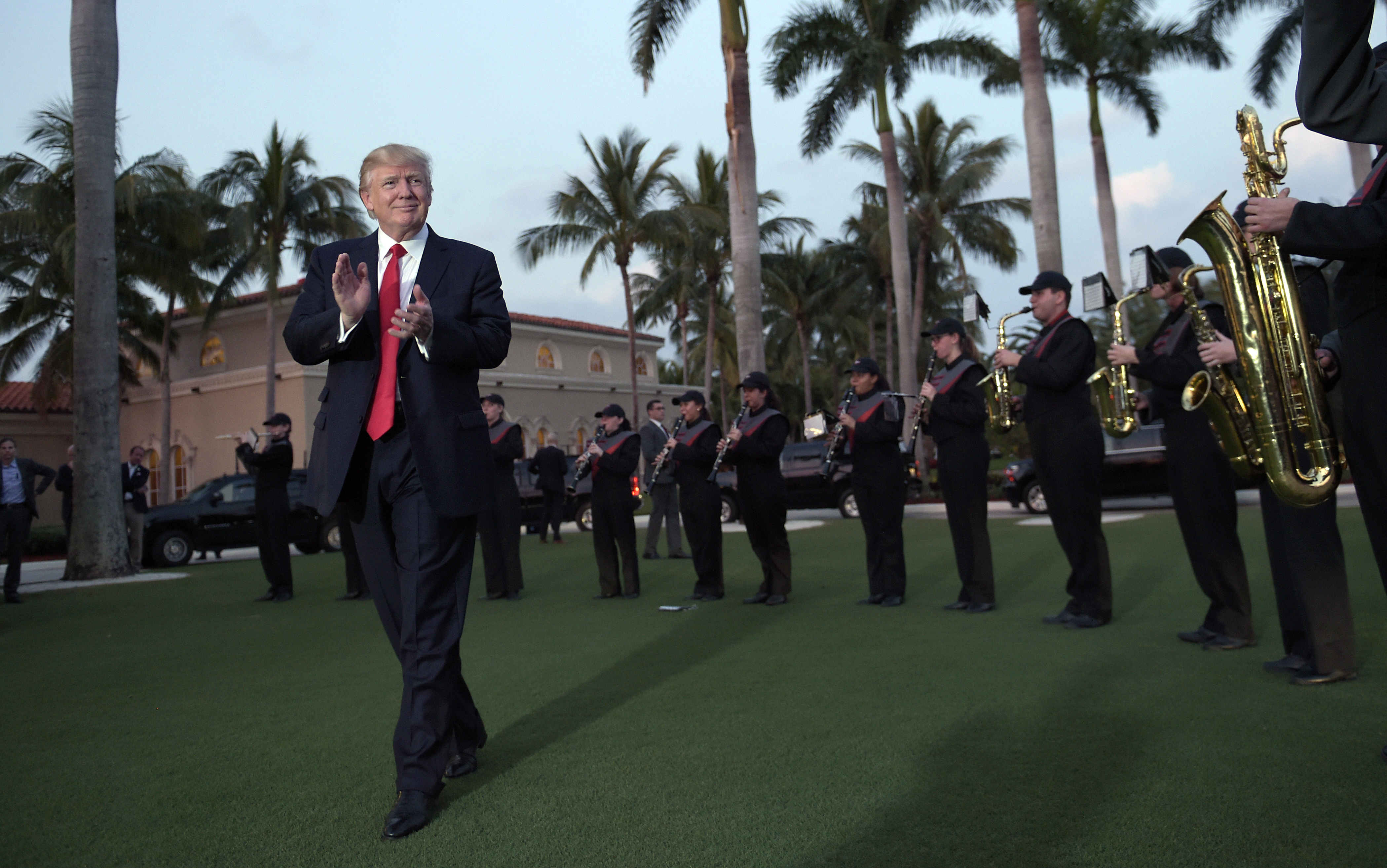 foto : susan walsh : day 17 - in this feb. 5, 2017, file photo, president donald trump listens to the palm beach central high school band as they play at his arrival at trump international golf club in west palm beach, fla. (ap photo/susan walsh, file)