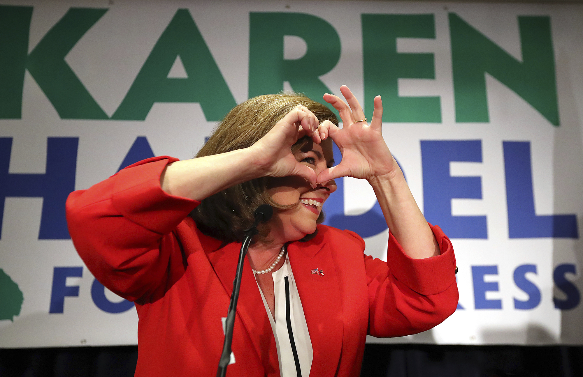 Karen Handel makes a heart symbol while making an early appearance to thank her supporters after the first returns came in during her election night party in the 6th District race with Jon Ossoff on Tuesday, June 20, 2017, in Atlanta. (Curtis Compton/Atlanta Journal-Constitution via AP)