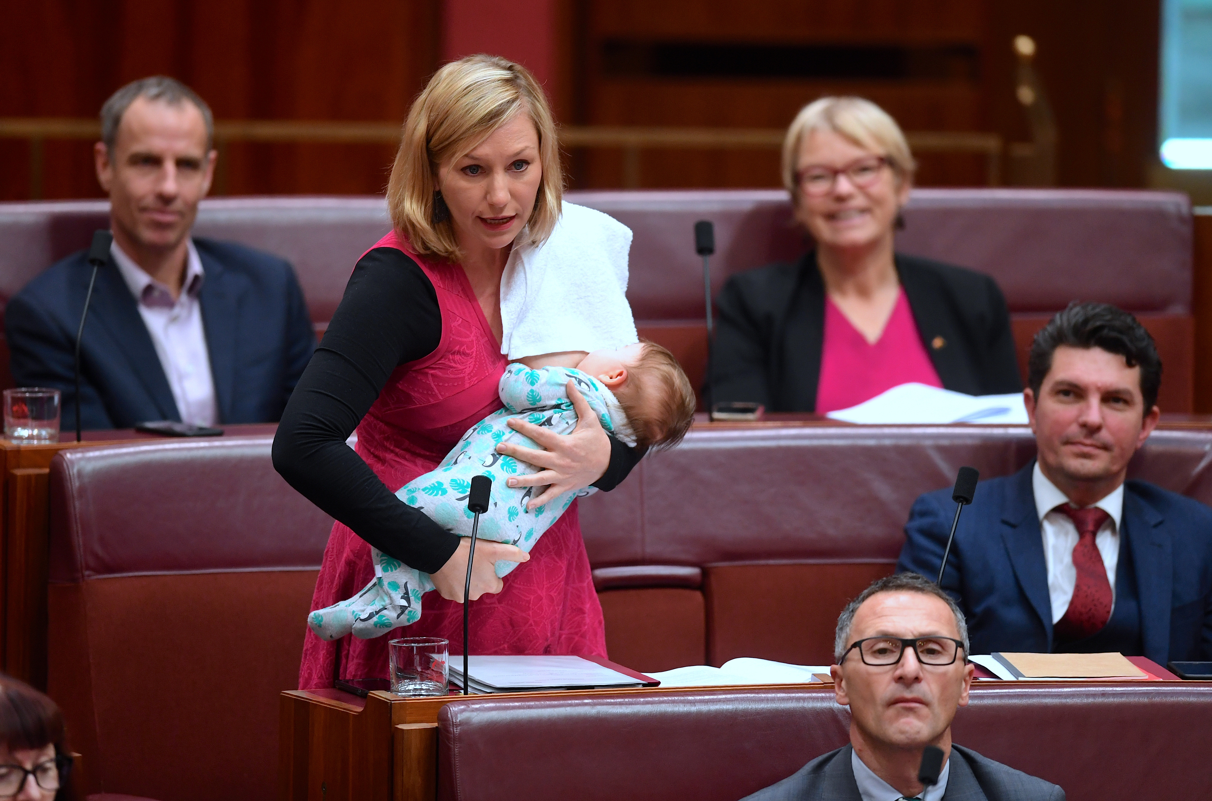 Den australiska senatorn Larissa Waters ammar sitt barn samtidigt som hon deltar i en debatt om skolfinansiering. REUTERS / TT