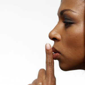 Young Businesswoman with Her Finger on Her Lips --- Image by © Royalty-Free/Corbis