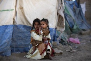A girl holds her sister outside their tent at a camp for people displaced by recent fighting between government forces and Shi'ite rebels in the northwestern Yemeni city of Saada December 13, 2011. REUTERS/Khaled Abdullah
